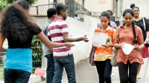 Uncertain future: Students who fear that the revision of the Z- score will hinder their admission to University  read leaflets pertaining to A Level revision classes last morning. Pic by Indika Handuwala