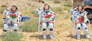 Chinese astronauts Jing Haipeng (C), Liu Wang (L) and Liu Yang, China's first female astronaut, salute in front of the re-entry capsule of China's Shenzhou 9 spacecraft in Siziwang Banner, Inner Mongolia Autonomous Region June 29, 2012. China's Shenzhou 9 spacecraft returned to Earth on Friday, ending a mission that put the country's first woman in space and completed a manned docking test critical to its goal of building a space station by 2020. REUTERS