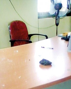 A stone with shattered glass lies on the judgs table inside his chambers