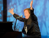 Beatles legend Sir Paul McCartney raises his arms as he sings at the end of the opening ceremony, as he brings the show to a close with a performance of Hey Jude. AFP.