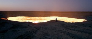 On the edge: Two people stand and look into the burning hole, which has become known as 'The Door to Hell'