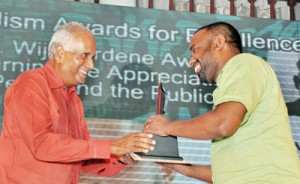 D.R. Wijewardene award for Earning the Appreciation of Peers and Public: Nuwan Gankanda of Lakbima (right) receiving the award from Editor, Sunday Island Manik de Silva