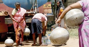 A woman with cash in her mouth waits for water to be measured out