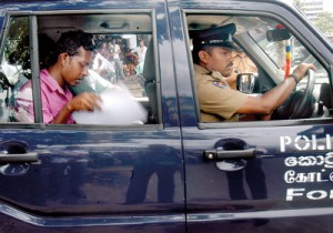 Picture shows Mr. Munasinghe in the Police jeep on the way to the Presidential Secretariat. Pic by Nilan Maligaspe