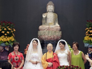You Ya-ting (2nd L) and Huang Mei-yu (2nd R) take a photograph with their friends and the Buddhist host Shih Chao-hwei (C) after casting their stamps during their symbolic same-sex Buddhist wedding ceremony at a temple in Taoyuan county, northern Taiwan, August 11 (REUTERS)