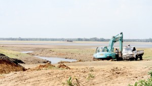 Backhoes at work: Digging up trenches so that the water below the sluice gates of the Parakrama Samudraya can be used.