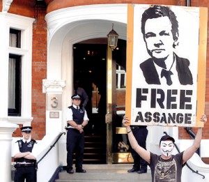 A protestor holds a poster of Wikileaks founder Julian Assange outside Ecuador's embassy in London on Friday. Reuters