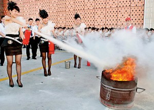 Training: Firefighters in eastern China jumped at the chance when they were asked to put 300 mini-skirted girls from a hostess bar through their paces