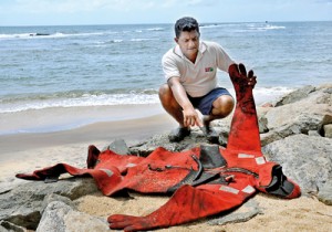 An oil-soaked diver’s kit washed ashore on the Negobom beach yesterday. Pic by Susantha Liyanawatte