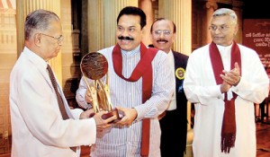 President Mahinda Rajapaksa presents a memento to Sam Wijesinhe at the ceremony yesterday while Speaker Chamal Rajapaksa looks on. Pic by Sudath Silva