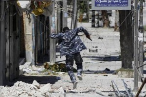 A Free Syrian Army fighter runs away to take cover from the exchange fire with regime forces in  Aleppo (REUTERS)