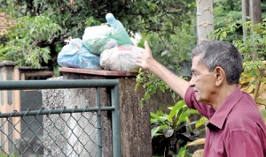 E. Karunarathne from Kotte points to the garbage collected on his gate post. Pix by Indika Handuwala