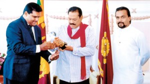 Proud to be a winner: State Engineering Corporation Chairman Jagath Kumara Perera accompanied by Housing and Construction Minister Wimal Weerawansa show the BID award, which the SEC paid and won, to President Mahinda Rajapaksa. This is a handout picture