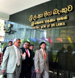 Defence Secretary Gotabaya Rajapaksa, Central Bank Governor Ajit Nivard Cabraal and Transport Secretary and businessman Dhammika Perera in conversation as they walk under the main name-board of the Central Bank (CB). The event was the beginning of construction of a new multi storied car park at the Bank premises. While the CB plays a crucial role as the country's banking regulator, it may also need to brush up its housekeeping - note the letter 'B' falling off on the sign. Pic by Amila Praboda.