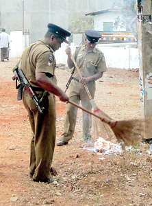 Doing more than their duty: Policemen at a booth in Anuradhapura collect ‘elections debris’  including leaflets with candidates numbers and set them alight. Pic by Manula Wickrama