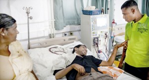Sampath Kumarasinghe talks to Ajantha, a potential kidney donor, while undergoing dialysis treatment at Anuradhapura General Hospital, Sri Lanka. Pic by Anna Barry-Jester for the Centre for Public Integrity