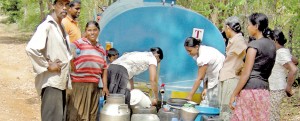 A sight for relieved eyes: Villagers in a remote corner of the Dimbulagala  Division fill up pots and pans from the weekly bowser