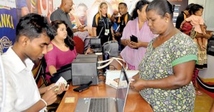 It’s all about getting your tickets: Brisk selling at the ICC counter at Thurstan College (above) and (below) tickets at a price from one party to another and an angry gesture by the blackmarketeer’s accomplice who sees our photographer taking a picture.