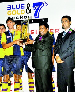 Royal captain Shahid Kuthubdeen receives the Blue & Gold Hockey 7s trophy form Asoka Pieris (CEO of Singer).