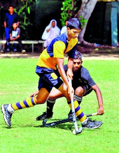 Royal skipper Kuthubdeen dribbles to pass the ball to a forward against Mahinda College in the first match of the tournament