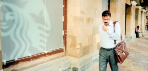 A pedestrian walks past a window, covered with translucent material, of Starbucks' first Indian outlet undergoing fitting in Mumbai on October 17. (AFP)