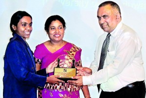 Executive Director Marketing of Ceylon Business Appliances, Johanne De Zilva, hands over the felicitation trophy to Woman Fide Master (WFM) Ms. Pramodya Senanayake.  Olympiad Gold Medalist Mrs. Suneetha Wijesuriya, Chairperson of Lanka Chess Foundation, who organized the programme at Colombo Hilton to commemorate the 20th year of the Chess Olympiad Gold Medal  is also in the picture.