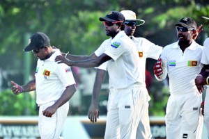 Spinner Rangana Herath (left) who took a five-for is congratulated by speedster Shaminda Eranga, who made the initial breakthrough after Sri Lanka bundled out New Zealand for 221. Pics by Amila Gamage