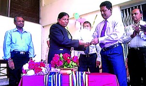 Deputy Post Master General Rajitha Ranasinghe presents her with a trophy