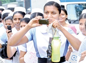 Nurses staged a token strike on Thursday and held demonstrations to protest over the Government's failure to meet their demands including overtime payments and risk allowances. Some nurses are seen using their cameras and phones to take pictures of their own protest held opposite the Health Ministry in Colombo. Pic by  Susantha Liyanawatte.