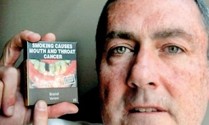 British American Tobacco Australia CEO David Crow displays one of the drab olive-green cigarette packets (AFP)