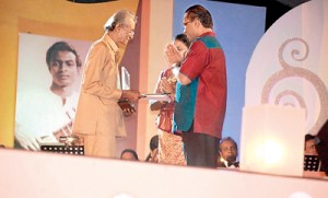Ivor receiving a memento from  Sunil Santha’s son Lanka