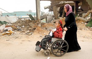 Palestinian children with special needs walk past buildings destroyed during the Gaza-Israeli conflict during a demonstration on the occasion of the UN International Day of People with Disability, on December 4, 2012 in Gaza City ( AFP)