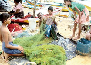 Young children join their parents  to clear the nets