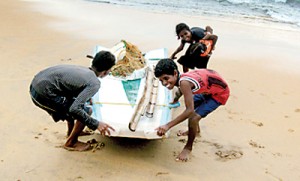 Children drag their  boat ashore