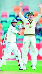 Thilan Samaraweera walks off after being dismissed as Ed Cowan celebrates on the second day of the first cricket Test match against Australia in Hobart - AFP