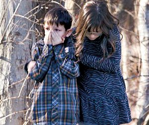 Young children wait outside Sandy Hook Elementary School after the shooting (REUTERS)