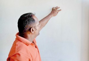 A resident shows the crack on a wall in his house