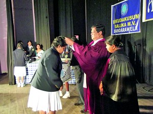 The Head Girl of the school Erandhi Munasinghe receiving her prize from the Chief Guest Hon. Bandula Gunawardana, The Minister of Education.