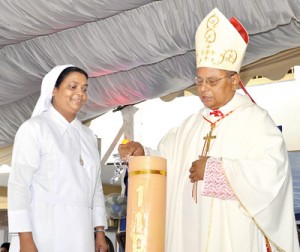 Cardinal Malcolm Ranjith lights the candle at Friday’s celebrations as Principal Sr. Chandani Jayasuriya looks on. Pic by Amila Gamage