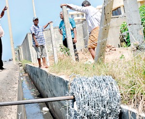 Residents preparing to rebuild walls that were needlessly brought down by the CMC.  Pix by Susantha Liyanawatte