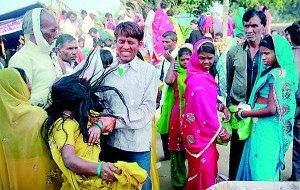 A man tries to hold a devotee who is believed to be possessed by evil spirits as she goes into a trance REUTERS)