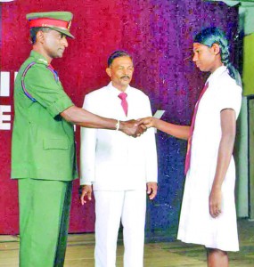 A prefect receives his badge from the chief guest Brigadier Ariyasinghe