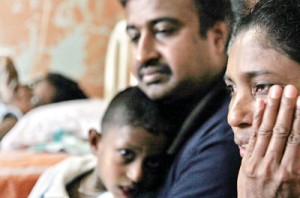 The picture says it all: Why us, asks Nilanthi as she sits at the bedside of her daughter Tharindi (above, inset) at the LRH along with her husband and little son, who is also showing signs of the disease.