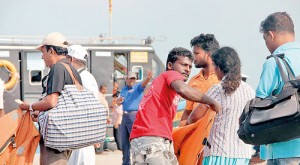 All aboard: A Navy personnel calls out to passengers  at the Kurikattuwan jetty