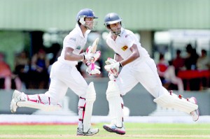 Dinesh Chandimal (L) and Lahiru Thirimanne (R) cross over for runs during their marathon unbroken partnership of 203 runs for the fifth wicket. Both Chandimal and Thirimanne went on to hit their debut Test tons on the second day against Bangladesh at Galle. 			                          - Pic by Shantha Ratnayake