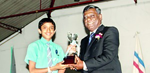 Lyceum Wattala Scrabble captain Migara Jayasinghe receiving the Overall Champion Trophy from the chief guest Wimal Fernando, the President of SLSL.