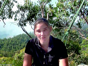 Smoke rises in the background from the approaching bush fire as protestor Miranda Gibson prepares to come back down to earth after her record-breaking protest