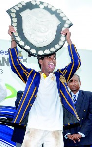 An elated Devind Pathmanathan holds aloft the D.S Senanayake Shield after receiving it from chief guest P.L.D. Kariyawasam -- the former Thomian skipper.