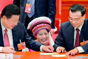 An ethnic delegate (C) gets the newly elected Chinese President Xi Jinping (L) and the newly elected Premier Li Keqiang (R) to sign an  autograph during the 12th National People's Congress (NPC) in the Great Hall of the People in Beijing on March 14. AFP