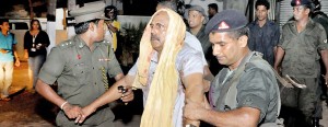 An injured employee of Fashion Bug being escorted by two Army officers for medical treatment. Pic Indika Handuwela